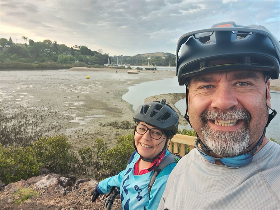 Cycling with a friend on a coastal trail overlooking an estuary